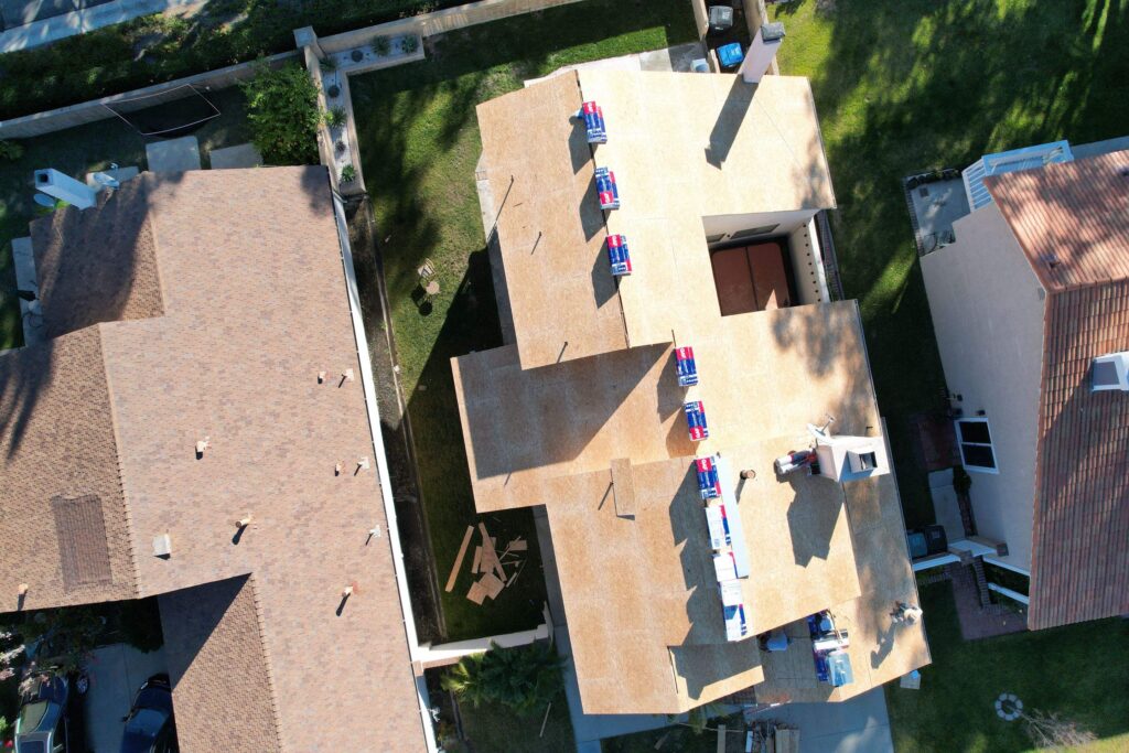  A newly installed plywood deck on a residential roof, providing a strong and even surface for the upcoming composition shingle installation
